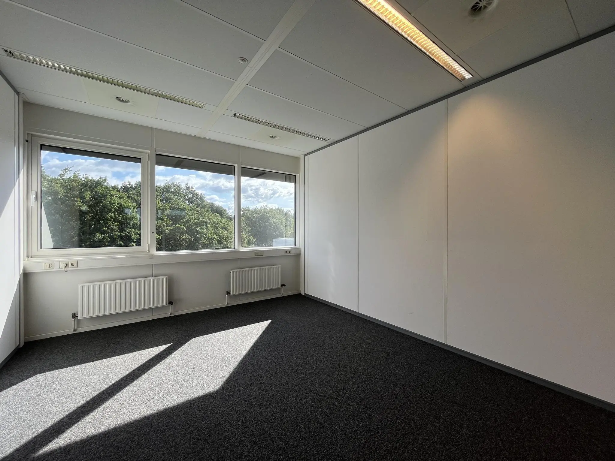 Lichte, lege kantoorruimte aan de Baarnsche Dijk met grote ramen en uitzicht op groen.